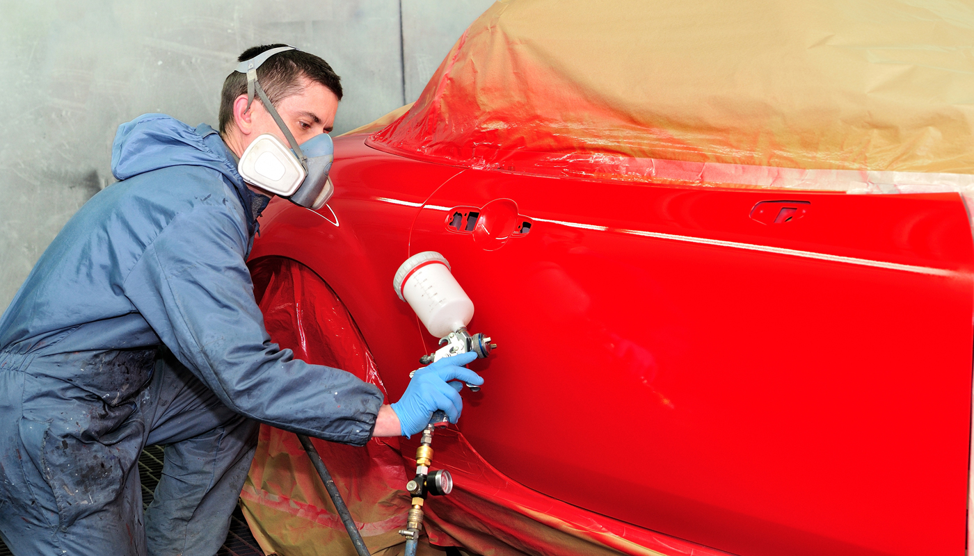Ung mann som lakkerer bil