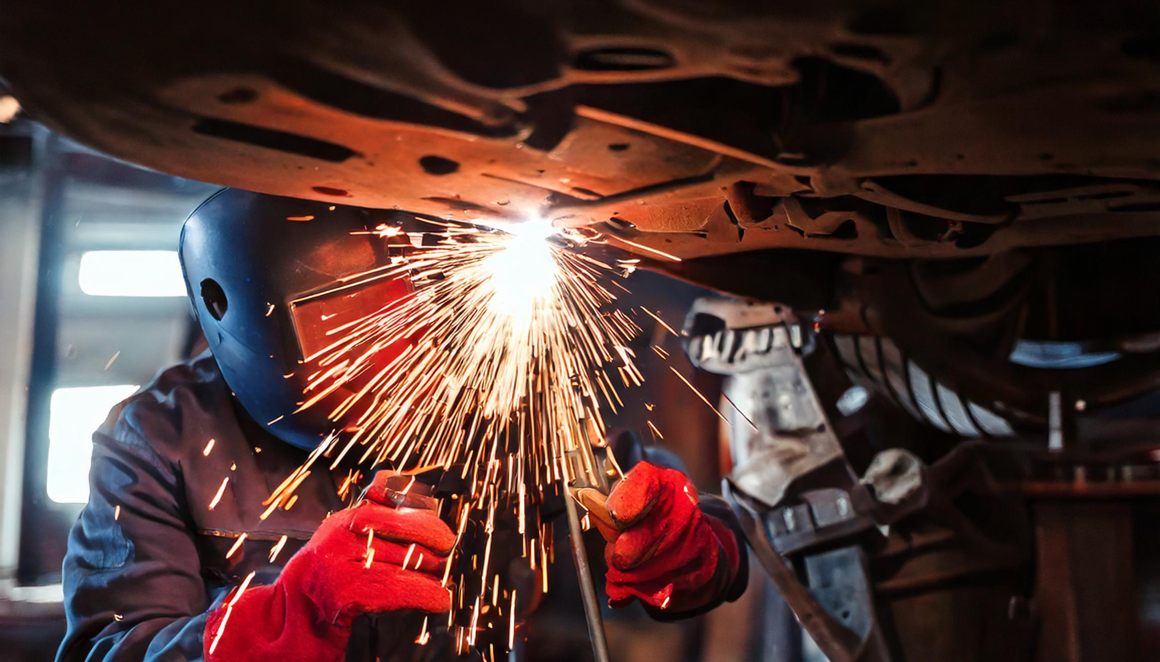 Person som sveiser på understellet til kjøretøy